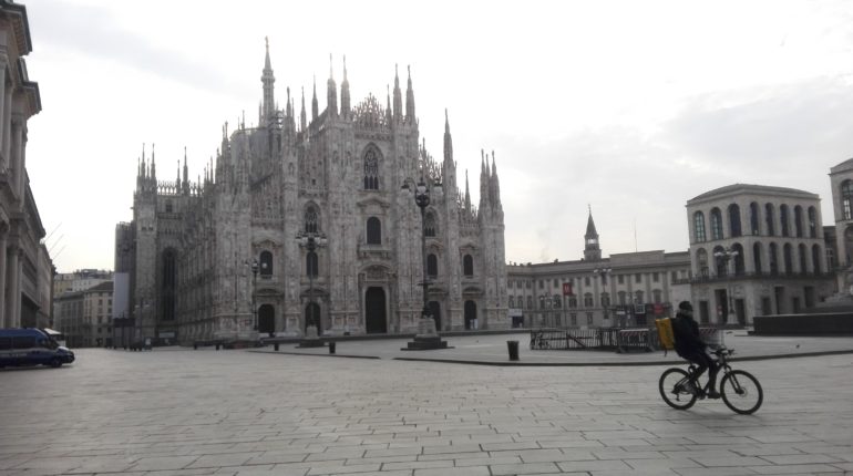 Un rider corre per piazza Duomo al tempo del coronavirus