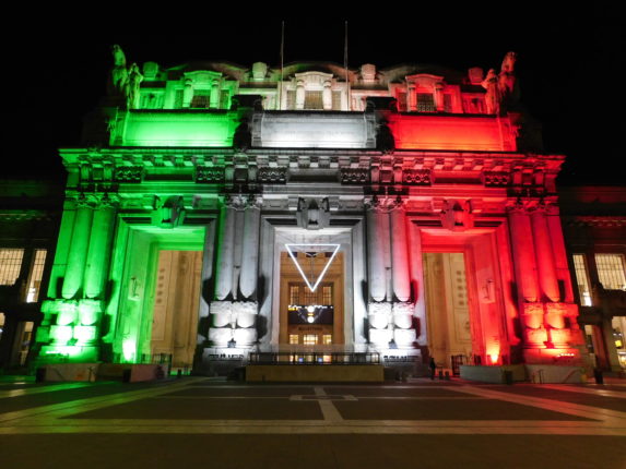 Stazione Milano Centrale illuminata con il tricolore durante l'emergenza coronavirus