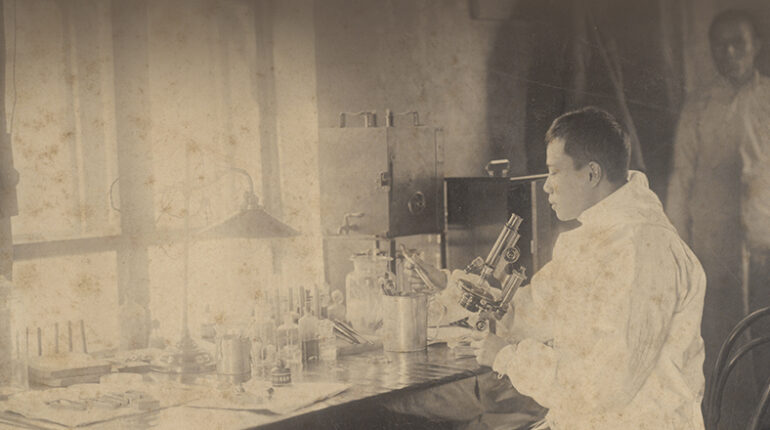 Il dottor Wu Lien-Teh mentre lavora al microscopio in Cina nel 1911
