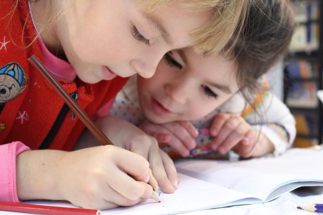 Bambini a scuola scrivono su dei fogli